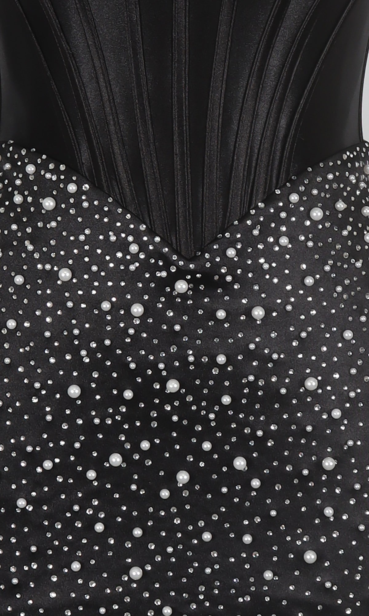 Close-up of the PromGirl Exclusive 250344, a black corset homecoming dress with a structured bodice and an embellished bodycon skirt decorated with white pearls in various sizes.